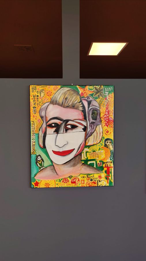 Quadro con volto di donna truccato, appeso in sala